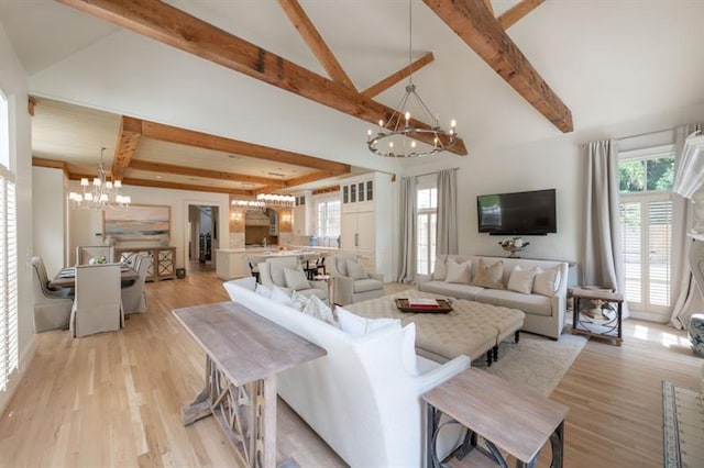 living room with light hardwood / wood-style flooring, vaulted ceiling with beams, and a notable chandelier