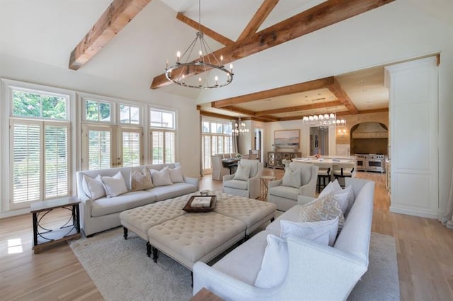 living room with high vaulted ceiling, beam ceiling, a chandelier, and light wood-type flooring