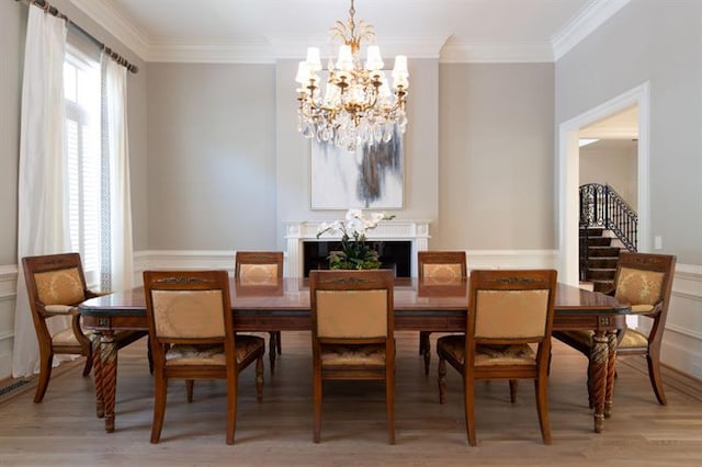 dining space with hardwood / wood-style floors, crown molding, and a chandelier