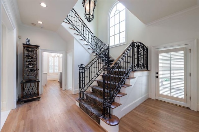 stairs with ornamental molding and hardwood / wood-style floors