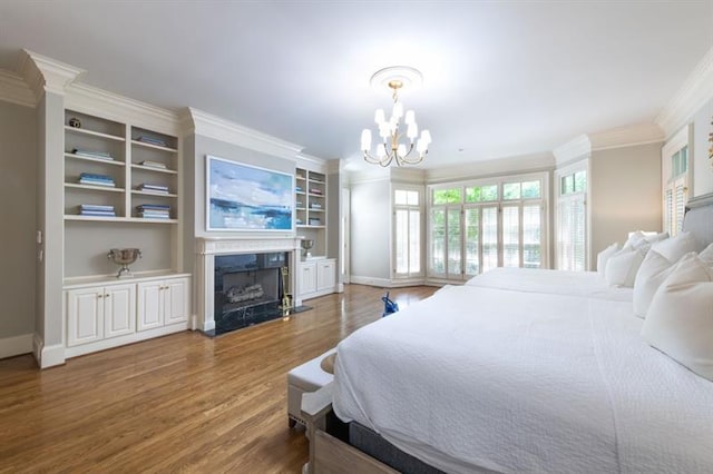 bedroom featuring a fireplace, dark wood-type flooring, an inviting chandelier, and ornamental molding