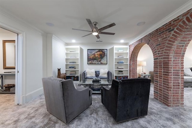 living room featuring ceiling fan, brick wall, ornamental molding, and carpet floors