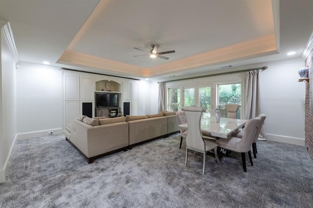 carpeted living room featuring ceiling fan, a tray ceiling, and ornamental molding