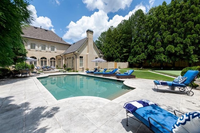 view of swimming pool featuring a patio area and a lawn