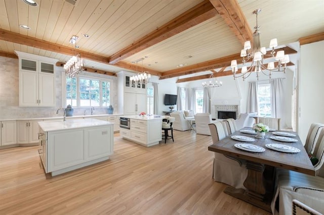 kitchen featuring light wood-type flooring, pendant lighting, a center island, and white cabinetry