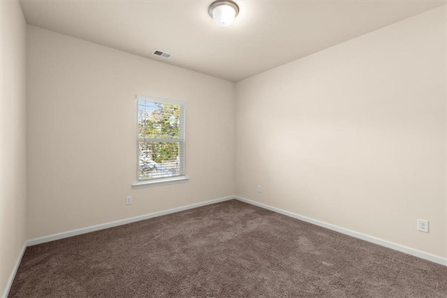 spare room with dark colored carpet