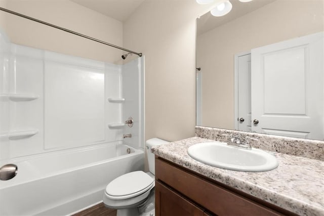 full bathroom featuring washtub / shower combination, hardwood / wood-style floors, vanity, and toilet