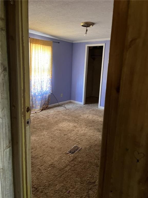 carpeted spare room with ornamental molding and a textured ceiling