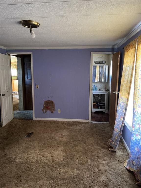 carpeted empty room with crown molding and a textured ceiling