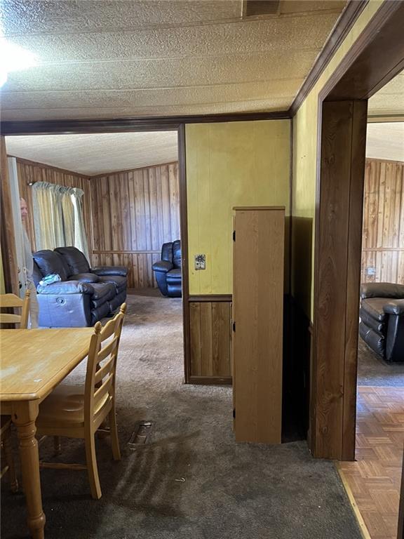 interior space featuring dark colored carpet and wooden walls