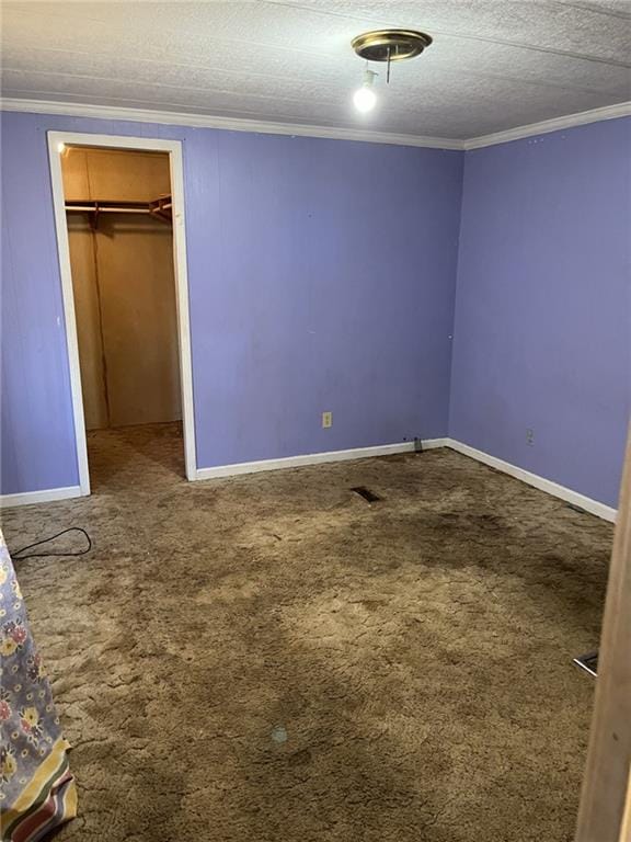 unfurnished bedroom featuring ornamental molding, carpet floors, a textured ceiling, and a closet