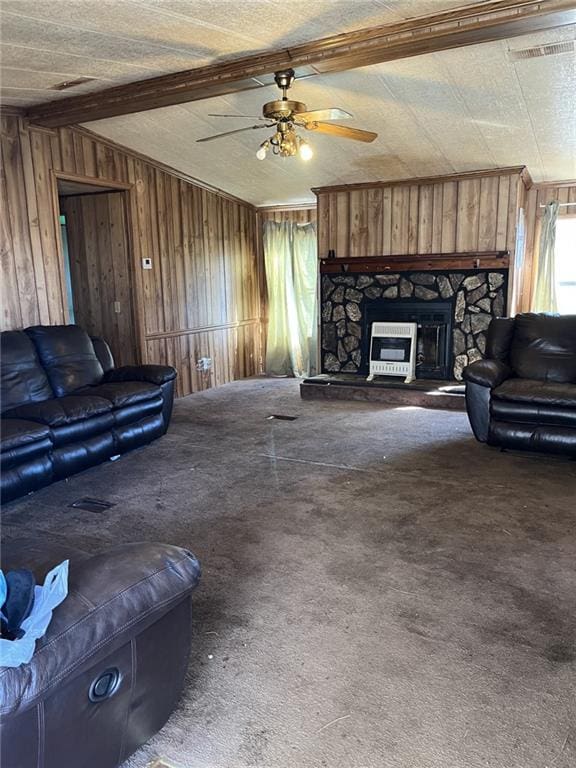 living room featuring ceiling fan, vaulted ceiling with beams, carpet floors, a fireplace, and wood walls