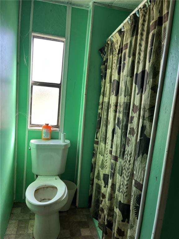 bathroom featuring a shower with shower curtain and toilet