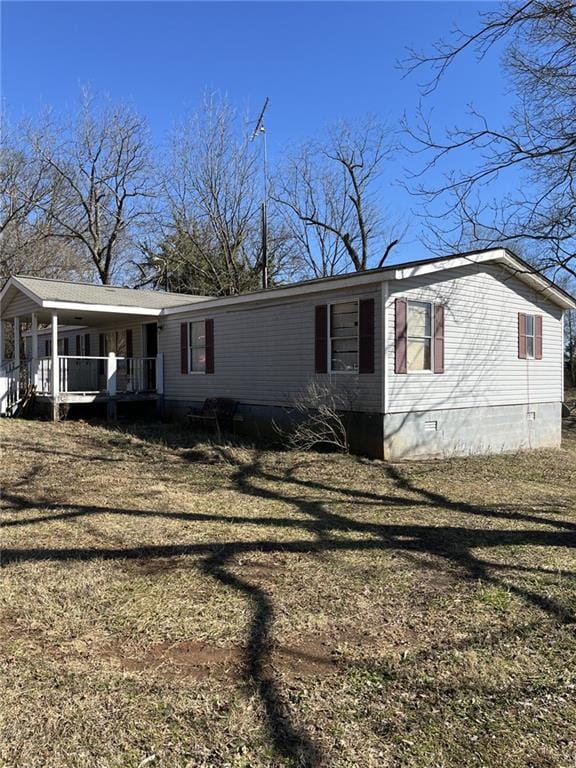 manufactured / mobile home with a front lawn and a porch