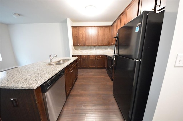 kitchen with black appliances, decorative backsplash, sink, dark wood-type flooring, and light stone counters