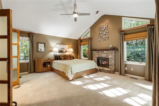 carpeted bedroom with ceiling fan, a fireplace, high vaulted ceiling, and multiple windows