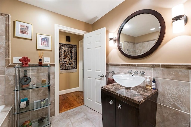 bathroom featuring hardwood / wood-style floors, vanity, and tile walls