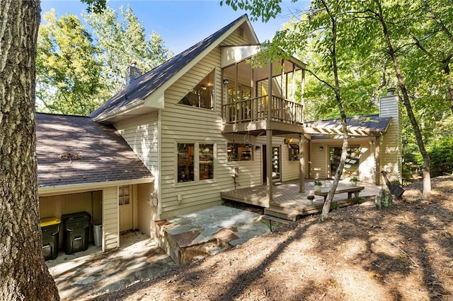 rear view of property with a deck and a patio area