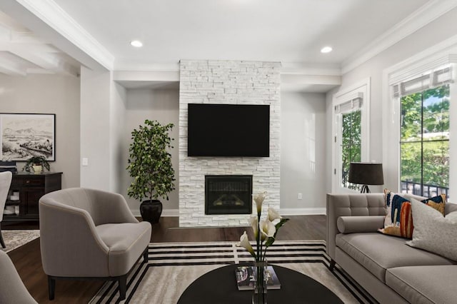 living room featuring dark hardwood / wood-style flooring, beam ceiling, ornamental molding, and a fireplace