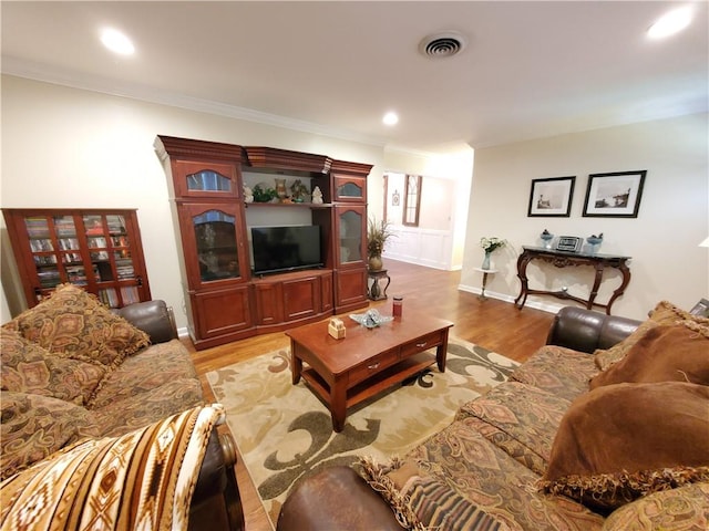 living room with crown molding and light hardwood / wood-style flooring