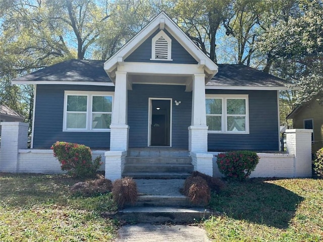 bungalow featuring a porch and roof with shingles