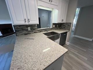 kitchen with backsplash, white cabinetry, hardwood / wood-style floors, and light stone countertops