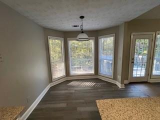 unfurnished dining area featuring a healthy amount of sunlight and dark hardwood / wood-style flooring