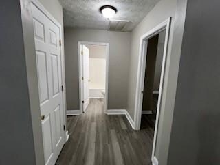 hallway featuring dark hardwood / wood-style floors and a textured ceiling