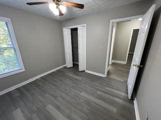 unfurnished bedroom featuring dark hardwood / wood-style flooring and ceiling fan