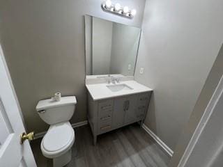 bathroom with vanity, wood-type flooring, and toilet