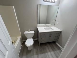 bathroom with toilet, vanity, and hardwood / wood-style flooring