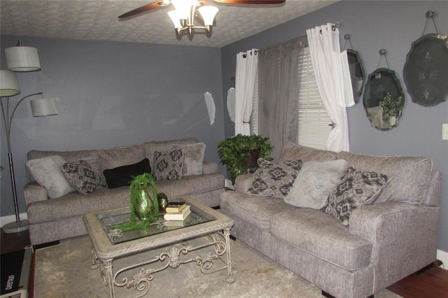 living room with ceiling fan and a textured ceiling