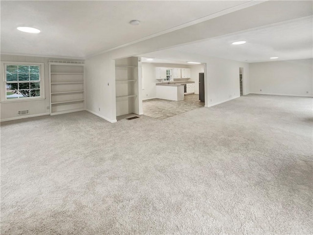 unfurnished living room featuring light carpet