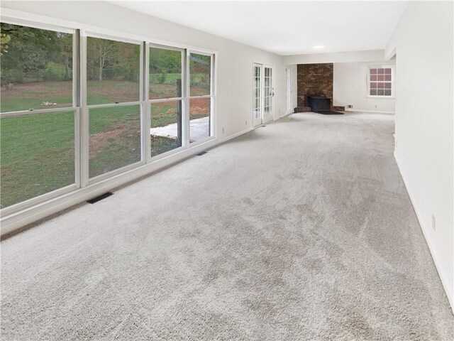 unfurnished living room featuring carpet and a fireplace