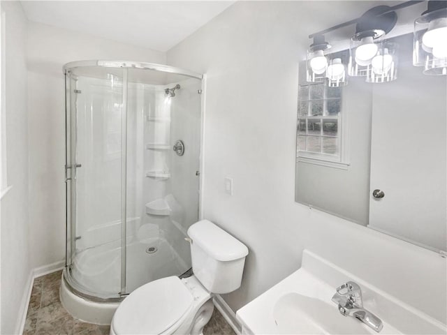 bathroom featuring sink, toilet, and a shower with door