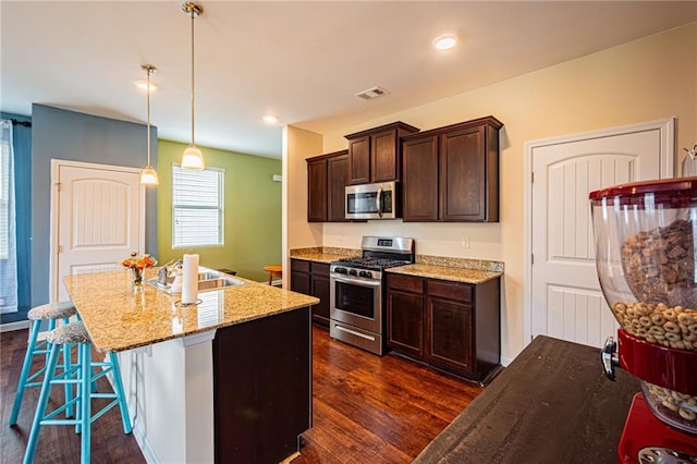 305 Thimbleberry Dr, Dawsonville, GA 30534 - kitchen featuring stainless steel appliances, dark brown cabinetry, a kitchen island with sink, and dark wood finished floors
