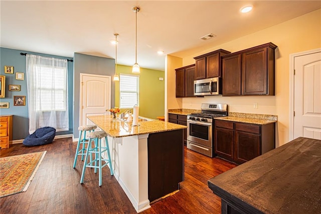 305 Thimbleberry Dr, Dawsonville, GA 30534 - kitchen with appliances with stainless steel finishes, dark wood-type flooring, a center island with sink, light stone counters, and recessed lighting
