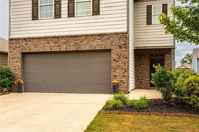 305 Thimbleberry Dr, Dawsonville, GA 30534 - view of exterior entry featuring brick siding, an attached garage, and driveway