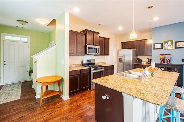 305 Thimbleberry Dr, Dawsonville, GA 30534 - kitchen featuring appliances with stainless steel finishes, dark brown cabinetry, a kitchen breakfast bar, dark wood-style flooring, and a kitchen island with sink