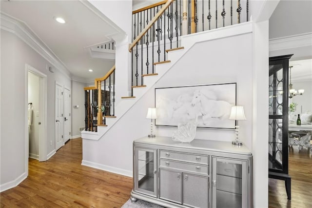 interior space featuring wood finished floors, crown molding, baseboards, stairs, and a notable chandelier