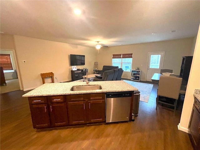 kitchen with dark wood finished floors, dishwasher, an island with sink, open floor plan, and a sink