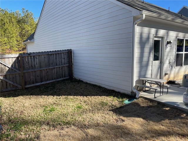 view of home's exterior featuring fence, a lawn, and a patio