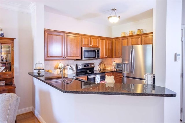 3202 Village Blvd, Rome, GA 30161 - kitchen featuring stainless steel appliances, a peninsula, dark stone counters, tasteful backsplash, and crown molding