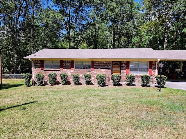 ranch-style home featuring a front lawn and a carport