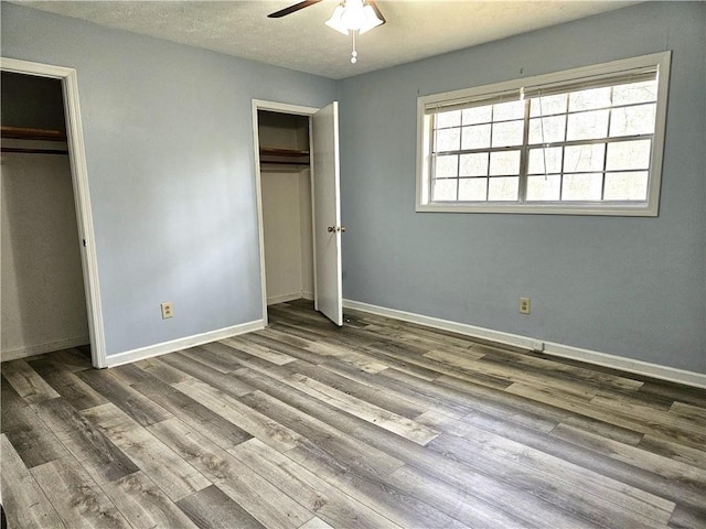 unfurnished bedroom with a textured ceiling, hardwood / wood-style flooring, and ceiling fan