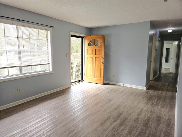 unfurnished room with a textured ceiling and dark hardwood / wood-style floors