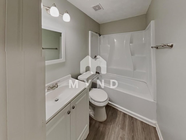 full bath featuring toilet, visible vents, vanity, wood finished floors, and shower / bathing tub combination