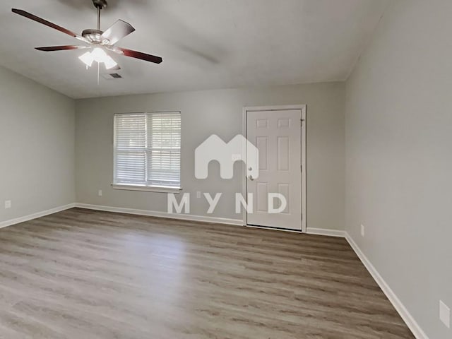 spare room featuring a ceiling fan, baseboards, visible vents, and wood finished floors