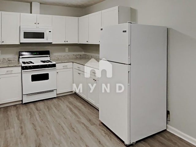 kitchen with white cabinetry, light wood-style flooring, white appliances, and light stone counters