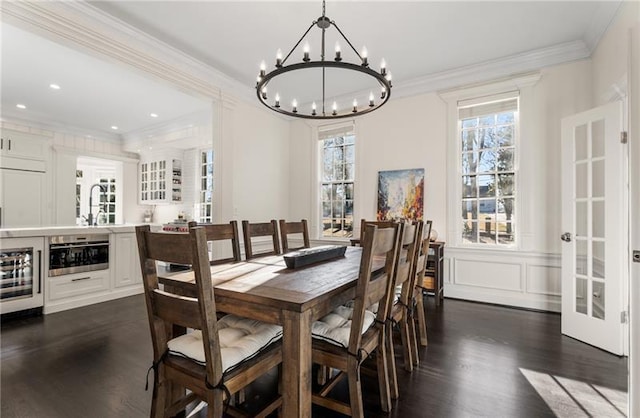 dining space featuring crown molding, a chandelier, dark hardwood / wood-style flooring, and beverage cooler